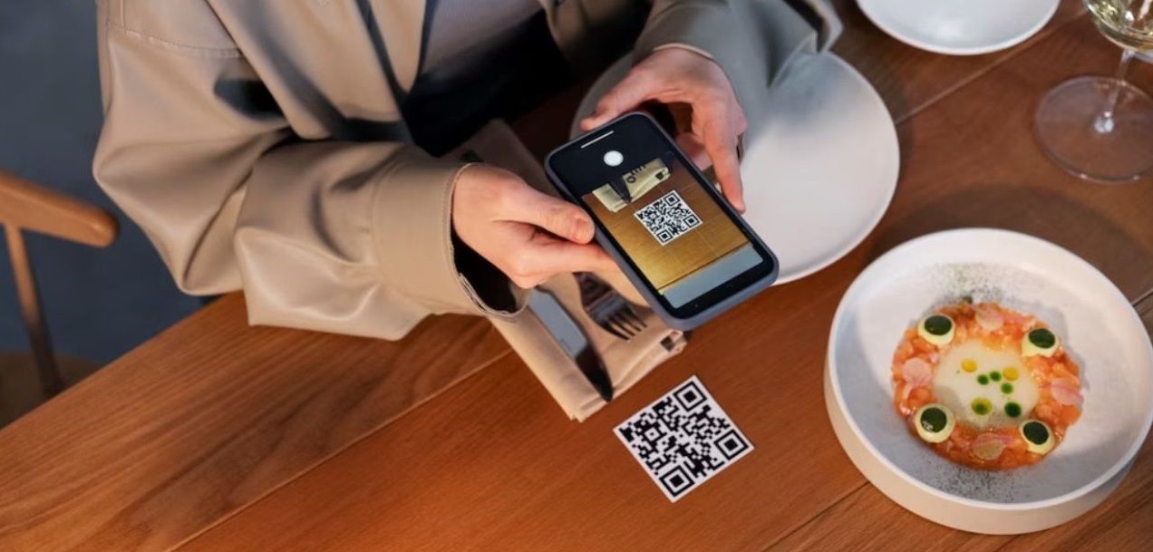 A guest scans a QR code at a restaurant table to open the digital menu